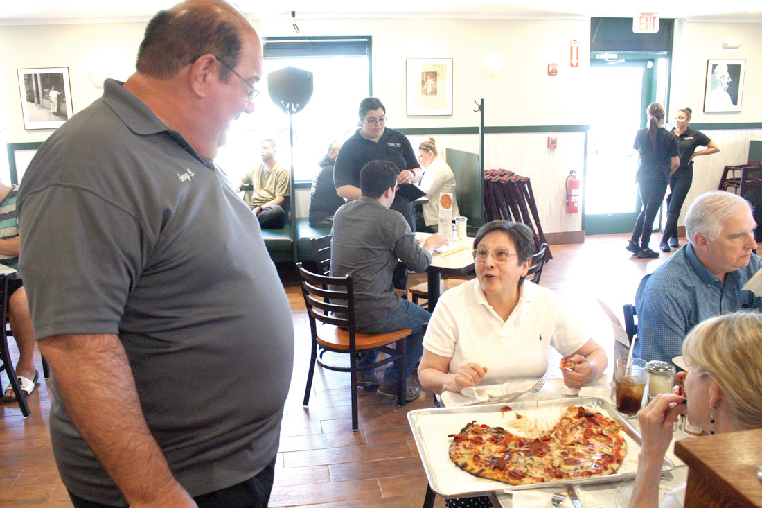 MEETING THE COMMUNITY: Gary Bimonte, who is the co-owner of Frank Pepe’s and the grandson of Frank Pepe, speaks with the patrons of their new location on Friday afternoon as they gave out free dine-in pizza.